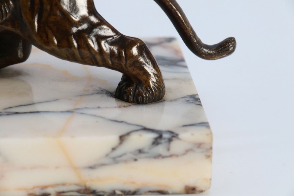 A dark bronze tiger sculpture posed in a roaring stance, mounted on a rectangular veined marble base. View XIII