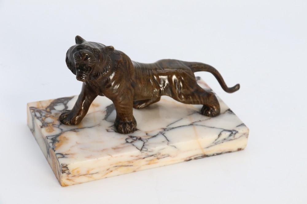 A dark bronze tiger sculpture posed in a roaring stance, mounted on a rectangular veined marble base. View XVII