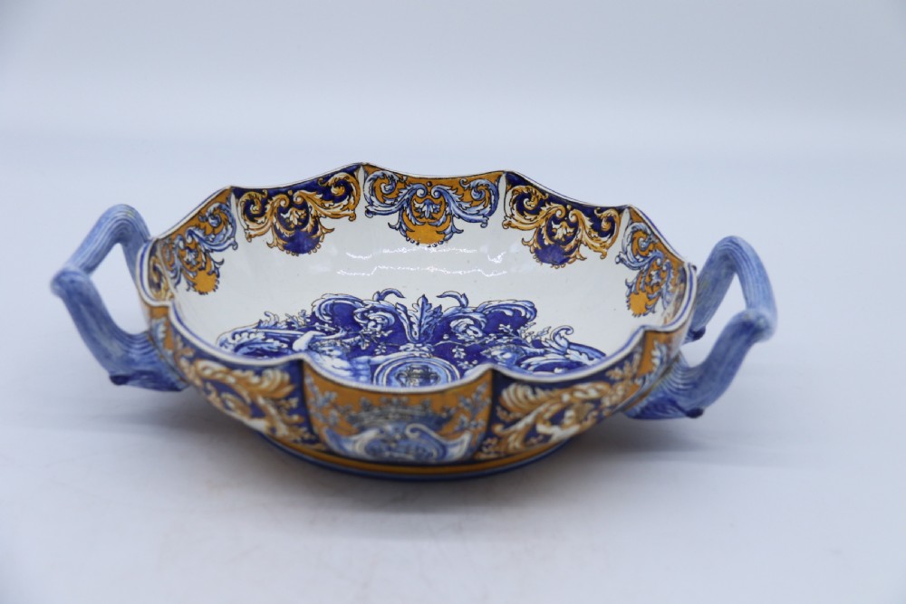 A hand-painted French Gien faience earthenware centrepiece dish with twin handles, decorated in cobalt blue and yellow mythological figures and acanthus scrollwork. View XXVI