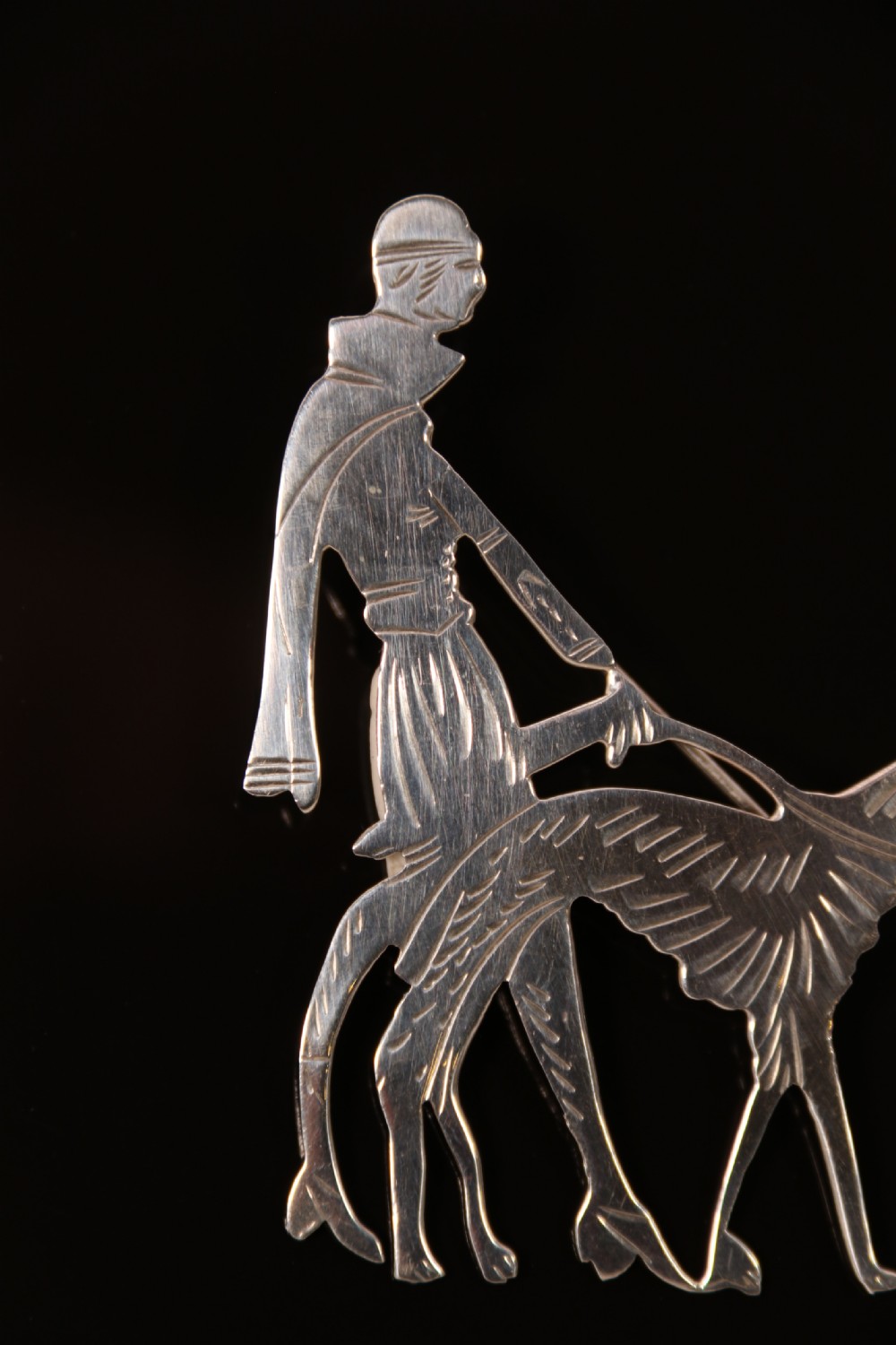 An Art Deco silver brooch  in the form of an elegant 1920s lady walking her borzoi dog. View II