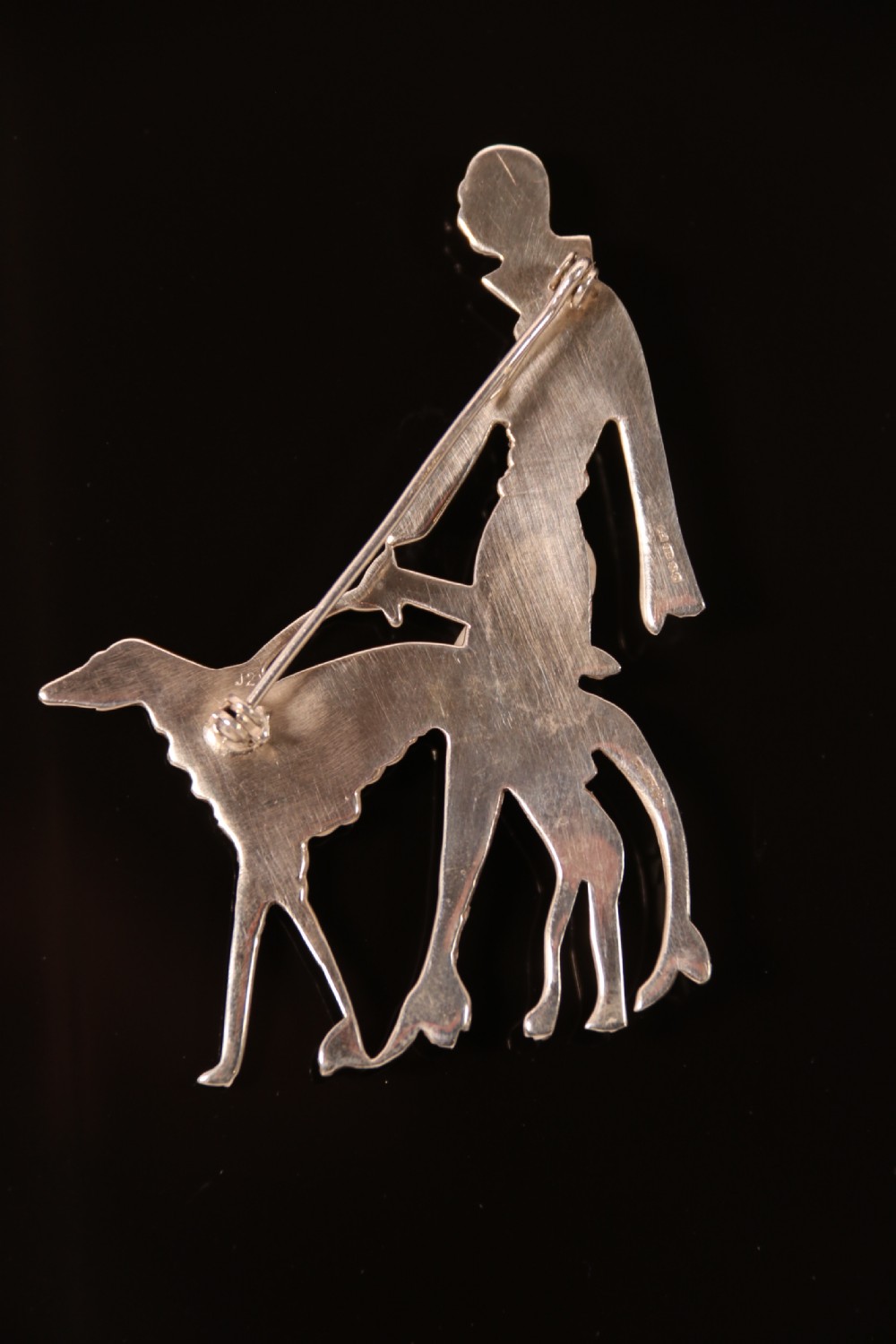 An Art Deco silver brooch  in the form of an elegant 1920s lady walking her borzoi dog. View V