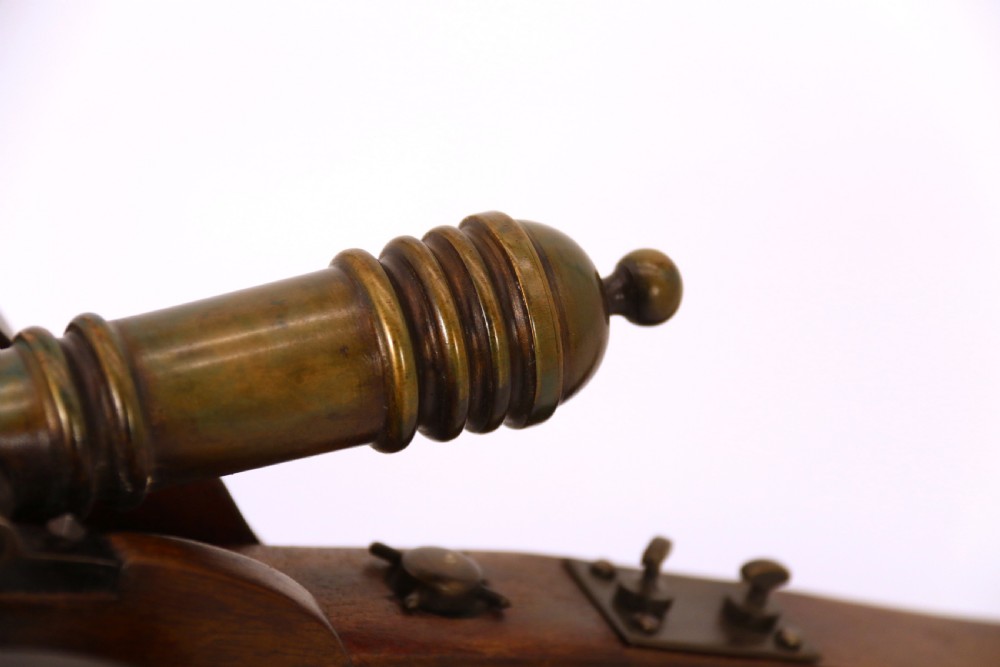 A detailed hand-built scale model of a 17th-century field cannon featuring a patinated brass barrel mounted on a dark timber carriage with spoked wheels. View XI