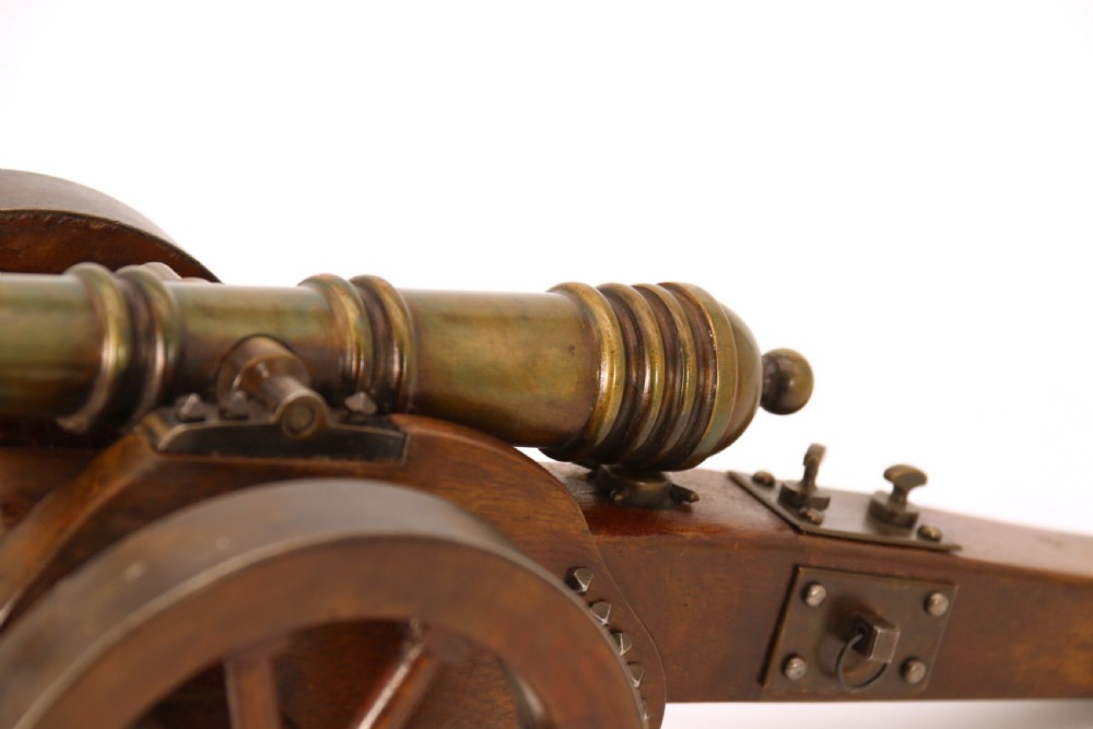 A detailed hand-built scale model of a 17th-century field cannon featuring a patinated brass barrel mounted on a dark timber carriage with spoked wheels. View XII