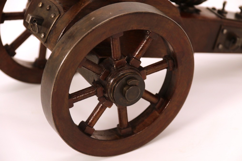 A detailed hand-built scale model of a 17th-century field cannon featuring a patinated brass barrel mounted on a dark timber carriage with spoked wheels. View XIII