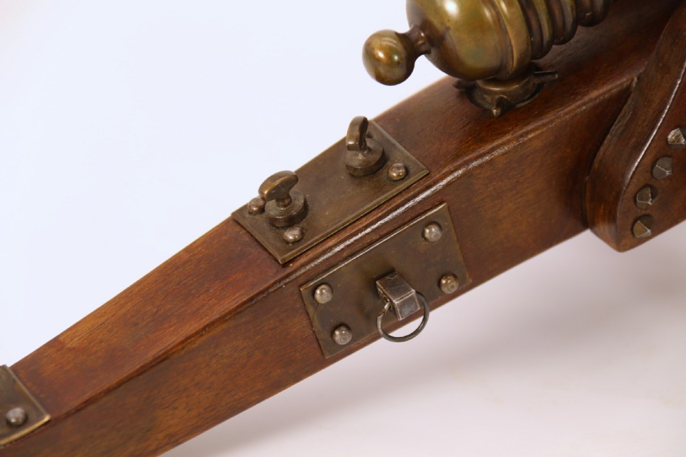 A detailed hand-built scale model of a 17th-century field cannon featuring a patinated brass barrel mounted on a dark timber carriage with spoked wheels. View XVI