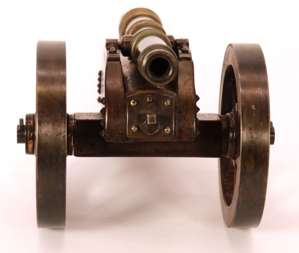 A detailed hand-built scale model of a 17th-century field cannon featuring a patinated brass barrel mounted on a dark timber carriage with spoked wheels. View XXI