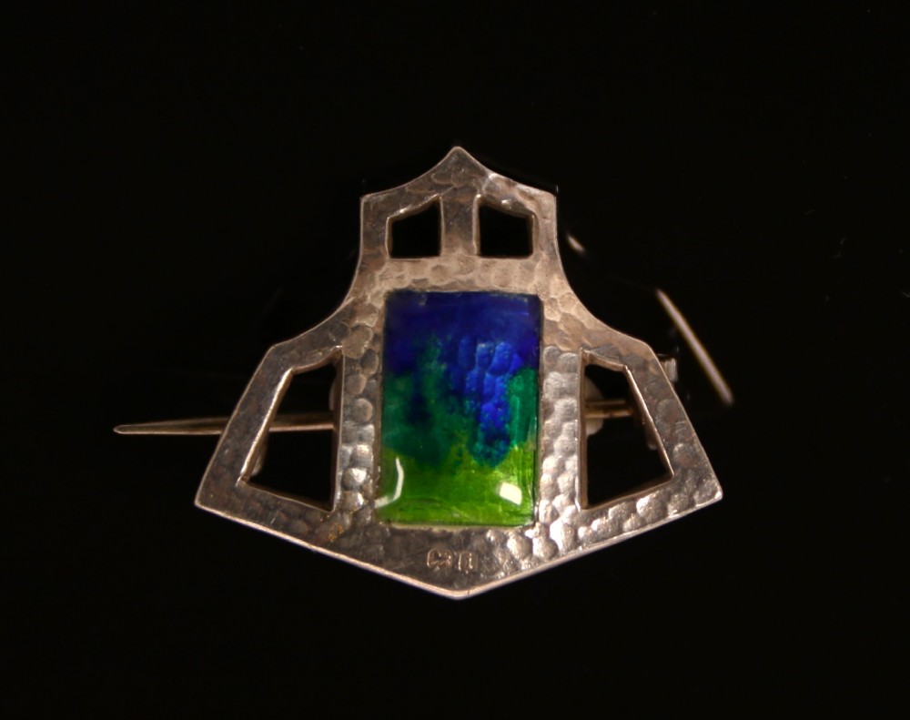 An antique Arts and Crafts hammered silver and enamelled brooch

