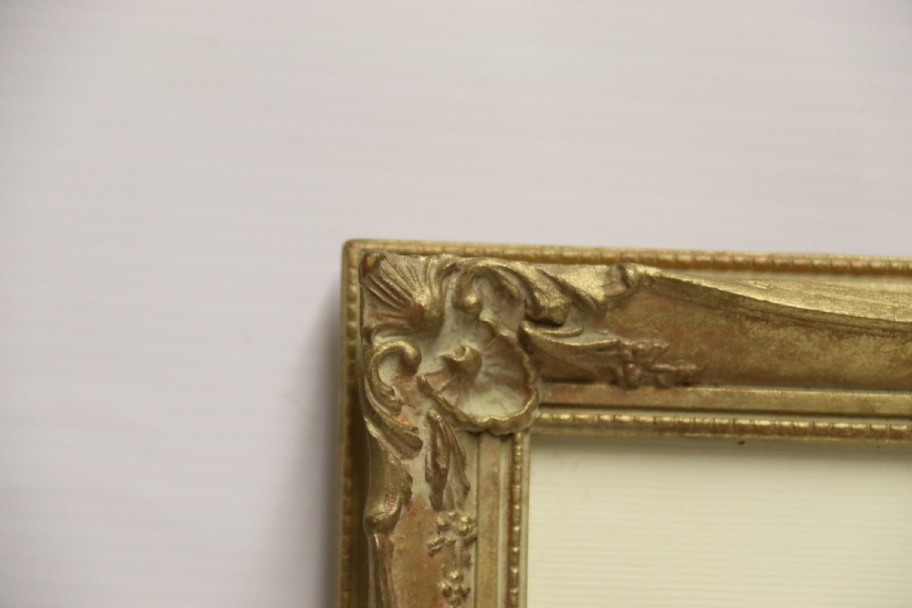 A framed 1920s watercolour landscape painting showing a stone building with vine foliage, set inside a decorative gilt frame with cream matting. View IV