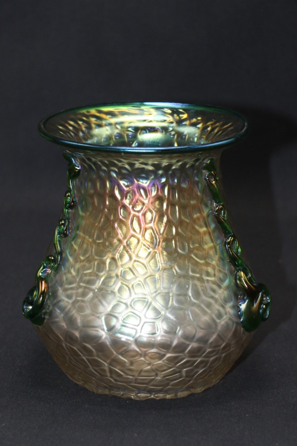 An Art Nouveau iridescent glass vase featuring a textured honeycomb pattern, a flared rim, and dark green applied glass trailings along the sides.