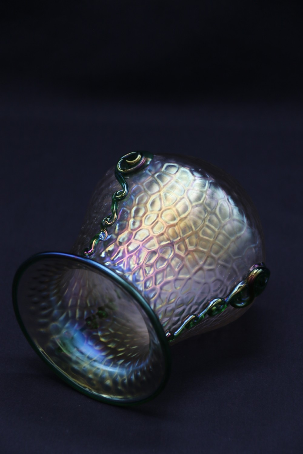 An Art Nouveau iridescent glass vase featuring a textured honeycomb pattern, a flared rim, and dark green applied glass trailings along the sides. View II