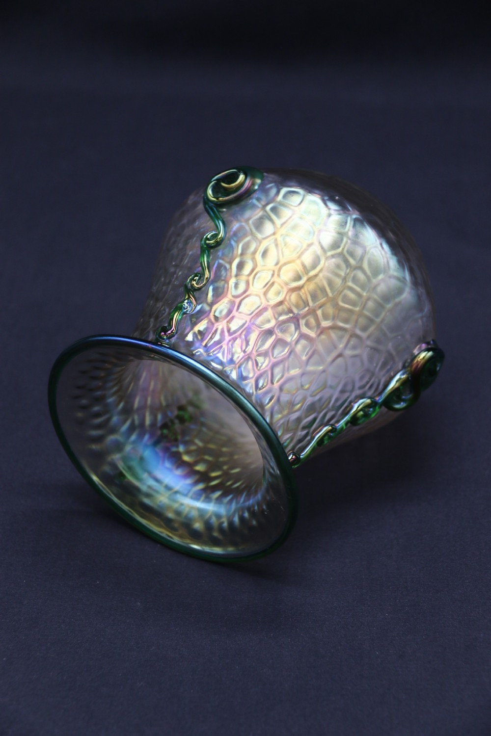 An Art Nouveau iridescent glass vase featuring a textured honeycomb pattern, a flared rim, and dark green applied glass trailings along the sides. View III