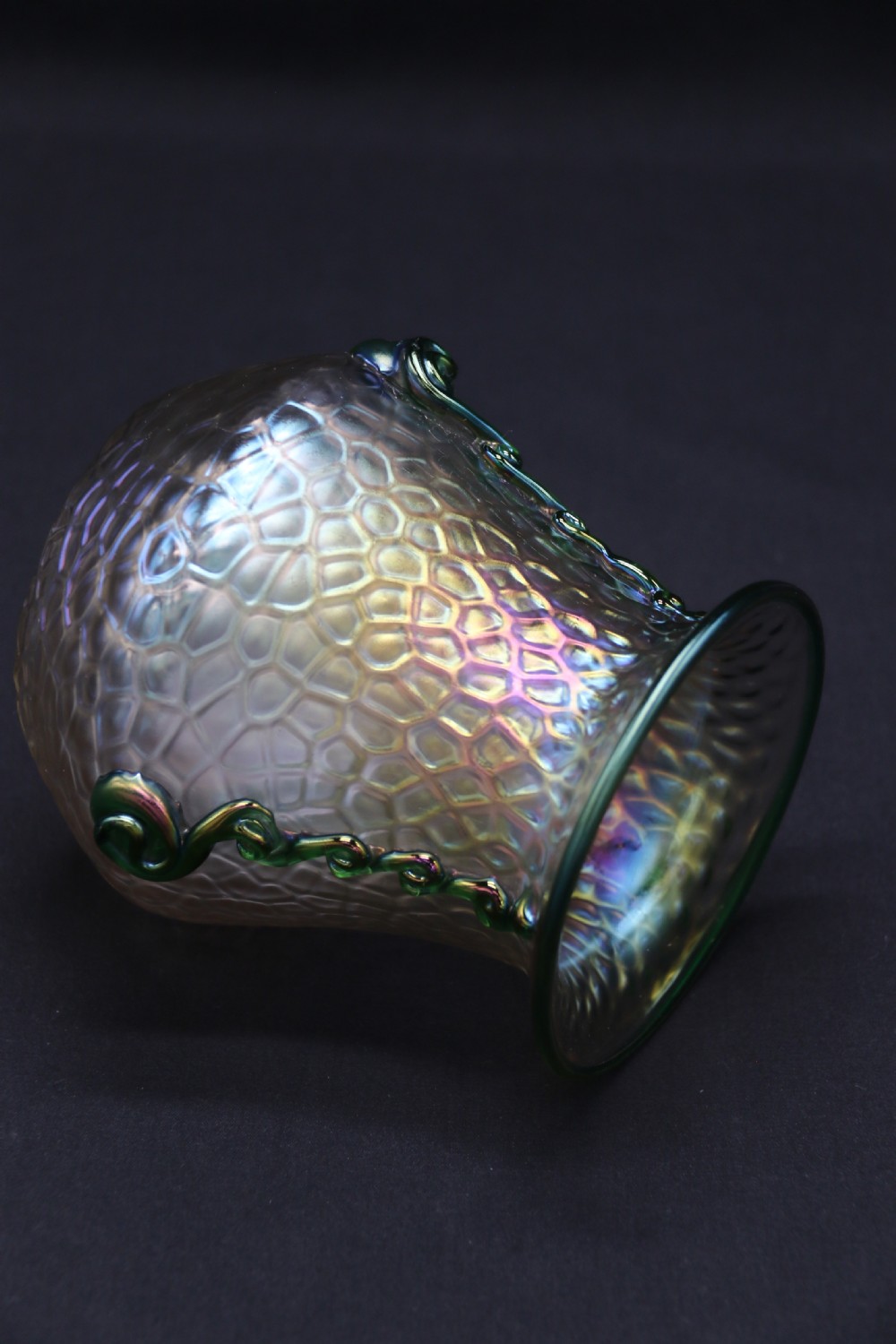 An Art Nouveau iridescent glass vase featuring a textured honeycomb pattern, a flared rim, and dark green applied glass trailings along the sides. View VI