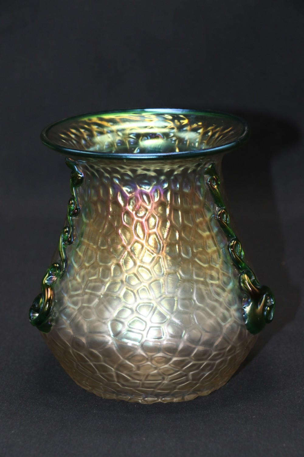 An Art Nouveau iridescent glass vase featuring a textured honeycomb pattern, a flared rim, and dark green applied glass trailings along the sides. View VII