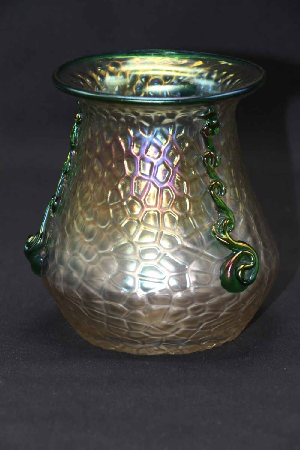 An Art Nouveau iridescent glass vase featuring a textured honeycomb pattern, a flared rim, and dark green applied glass trailings along the sides. View IX