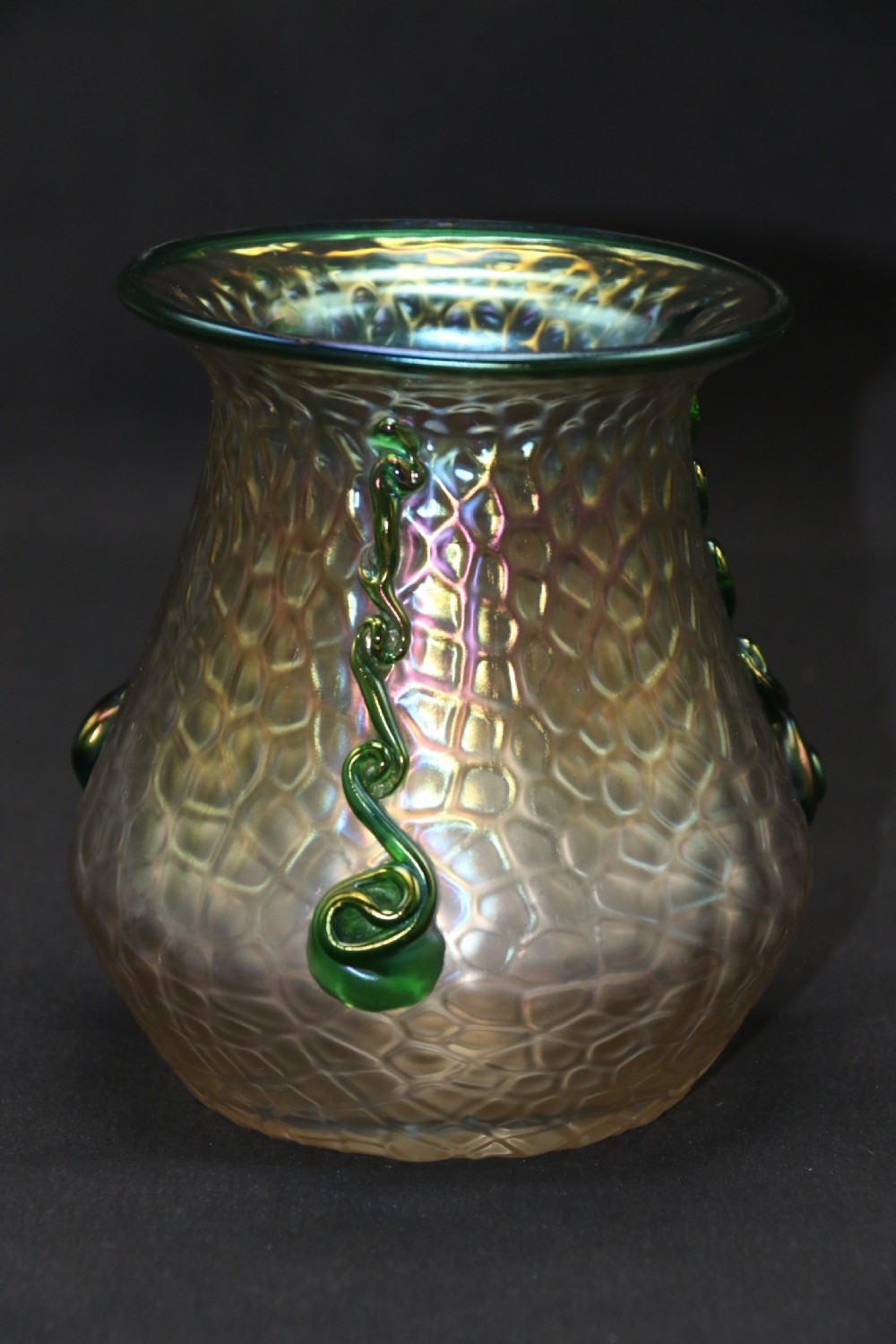 An Art Nouveau iridescent glass vase featuring a textured honeycomb pattern, a flared rim, and dark green applied glass trailings along the sides. View X