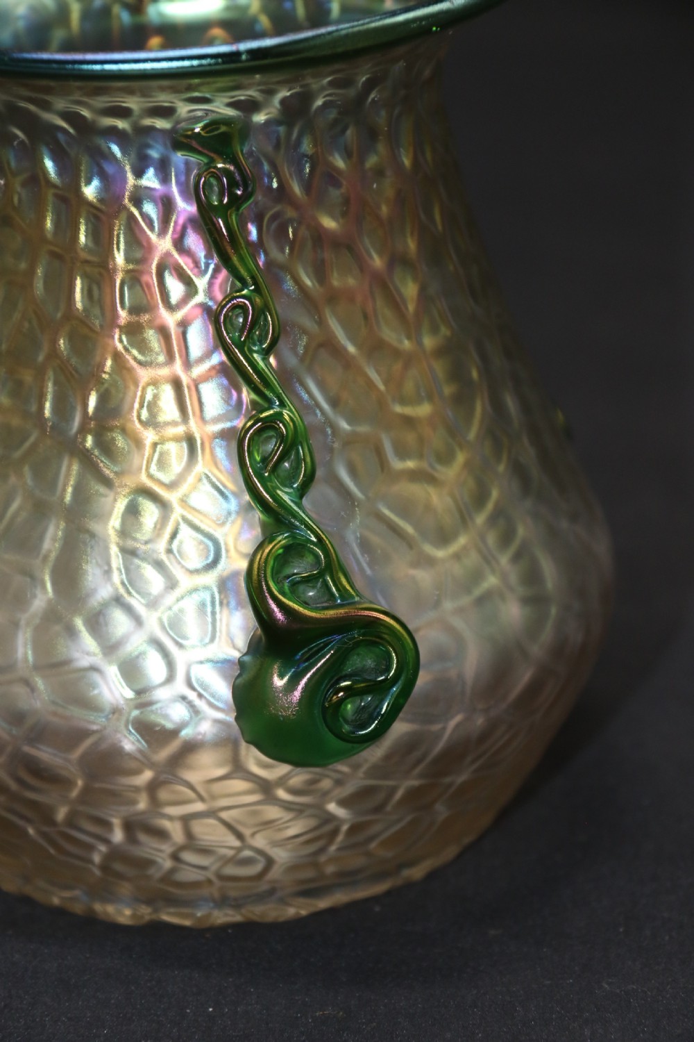 An Art Nouveau iridescent glass vase featuring a textured honeycomb pattern, a flared rim, and dark green applied glass trailings along the sides. View XII