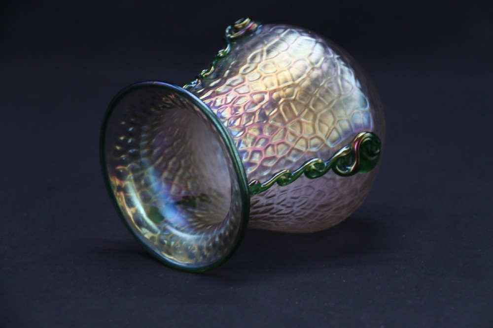 An Art Nouveau iridescent glass vase featuring a textured honeycomb pattern, a flared rim, and dark green applied glass trailings along the sides. View XV