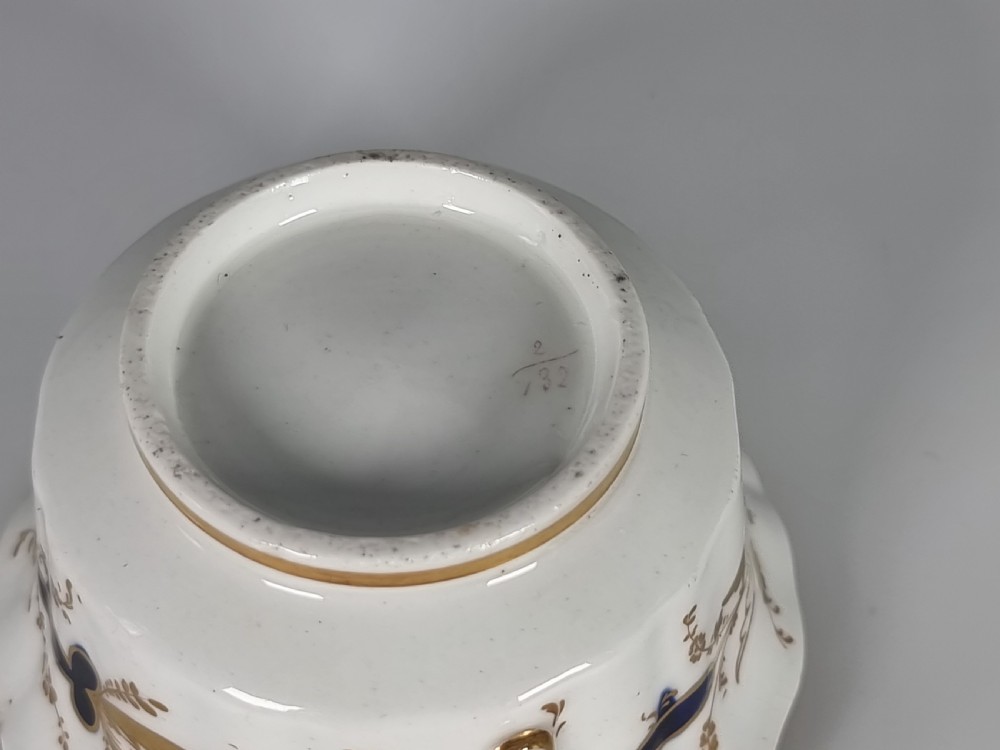 An early nineteenth-century Coalport porcelain cabinet trio featuring a teacup, coffee cup, and saucer styled with cobalt blue borders, gilded detailing, and hand-painted white rose panels. View XIII