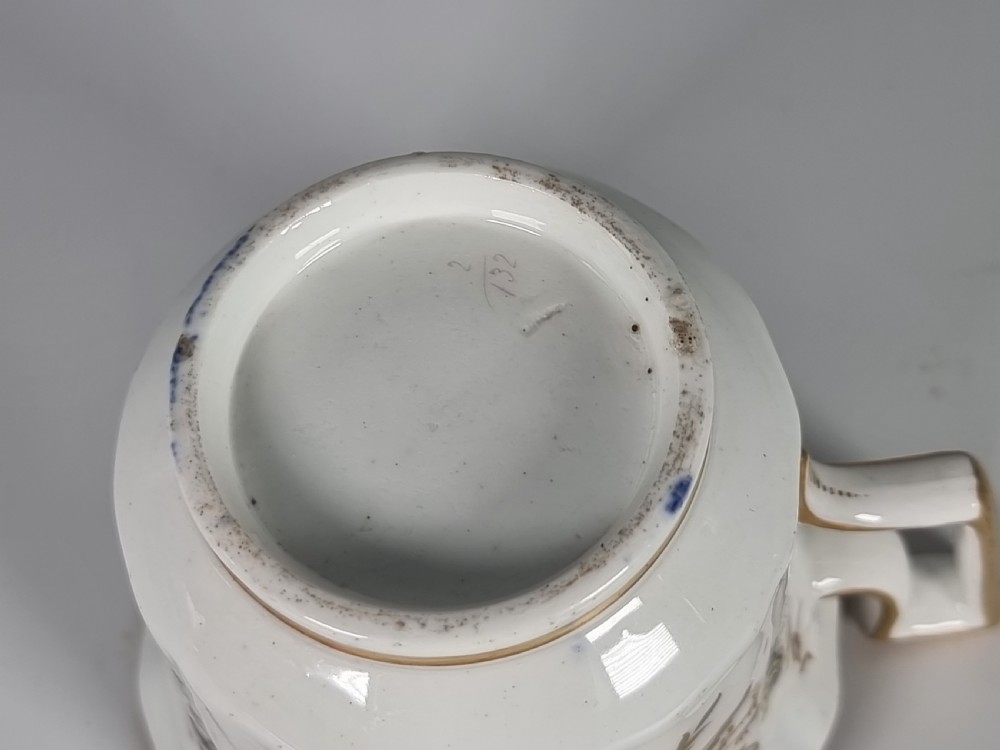An early nineteenth-century Coalport porcelain cabinet trio featuring a teacup, coffee cup, and saucer styled with cobalt blue borders, gilded detailing, and hand-painted white rose panels. View XXIII