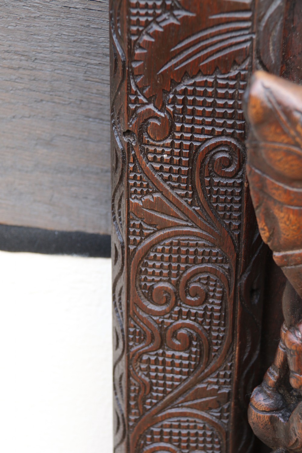 A dark hardwood rectangular panel featuring high-relief carvings of figures riding bullocks and a cart within an ornate carved border. View XIII