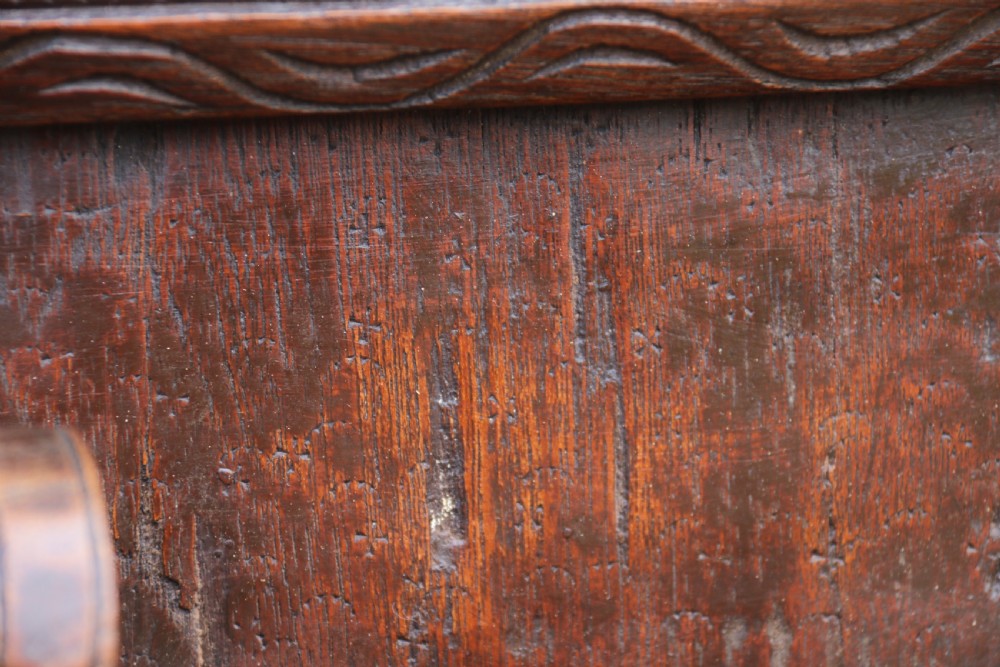 A dark hardwood rectangular panel featuring high-relief carvings of figures riding bullocks and a cart within an ornate carved border. View XIV