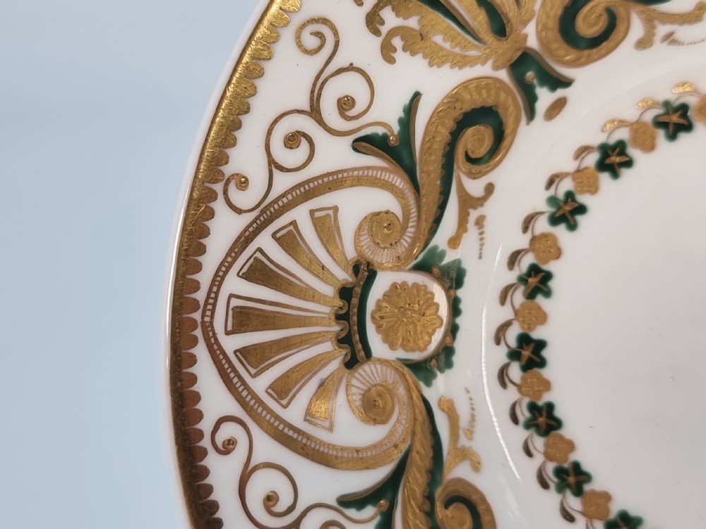 An early 19th-century Spode porcelain cabinet trio consisting of a teacup, coffee cup, and saucer adorned with intricate gold gilding and green scrollwork. View V