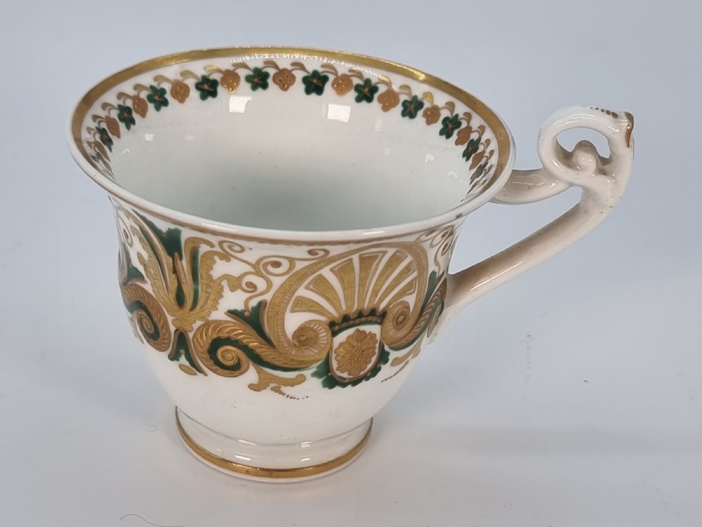 An early 19th-century Spode porcelain cabinet trio consisting of a teacup, coffee cup, and saucer adorned with intricate gold gilding and green scrollwork. View X