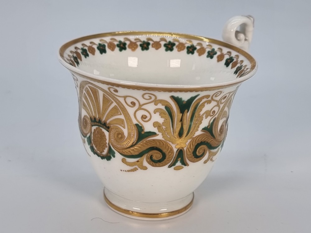 An early 19th-century Spode porcelain cabinet trio consisting of a teacup, coffee cup, and saucer adorned with intricate gold gilding and green scrollwork. View XI