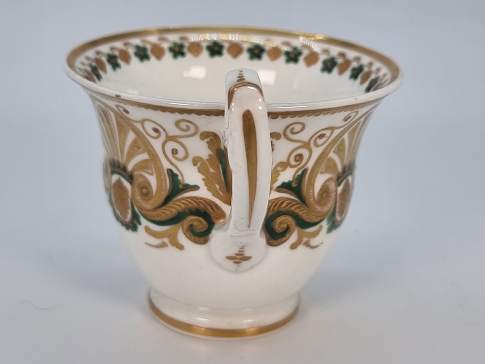 An early 19th-century Spode porcelain cabinet trio consisting of a teacup, coffee cup, and saucer adorned with intricate gold gilding and green scrollwork. View XIV