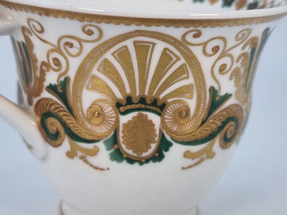 An early 19th-century Spode porcelain cabinet trio consisting of a teacup, coffee cup, and saucer adorned with intricate gold gilding and green scrollwork. View XV