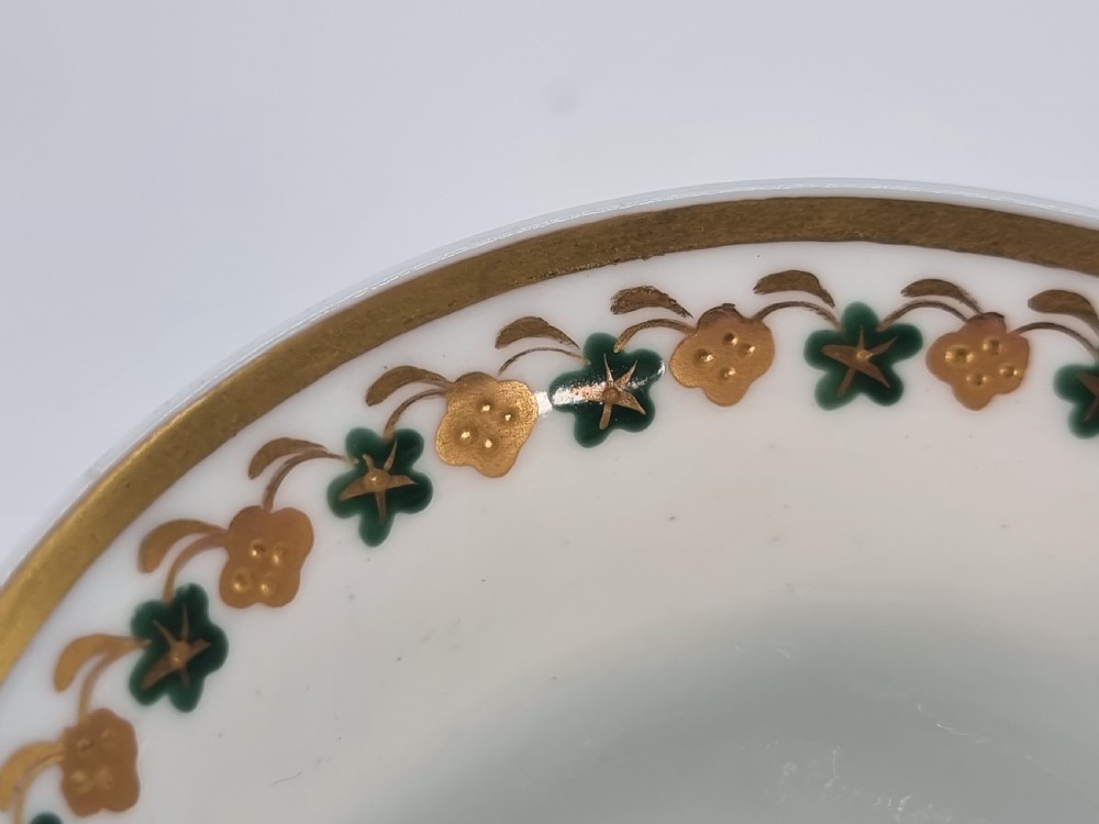 An early 19th-century Spode porcelain cabinet trio consisting of a teacup, coffee cup, and saucer adorned with intricate gold gilding and green scrollwork. View XVII