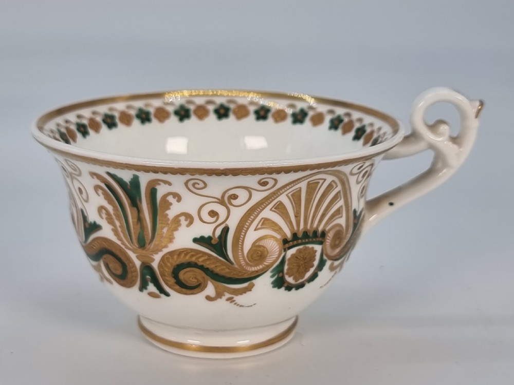 An early 19th-century Spode porcelain cabinet trio consisting of a teacup, coffee cup, and saucer adorned with intricate gold gilding and green scrollwork. View XIX