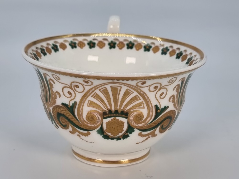 An early 19th-century Spode porcelain cabinet trio consisting of a teacup, coffee cup, and saucer adorned with intricate gold gilding and green scrollwork. View XX