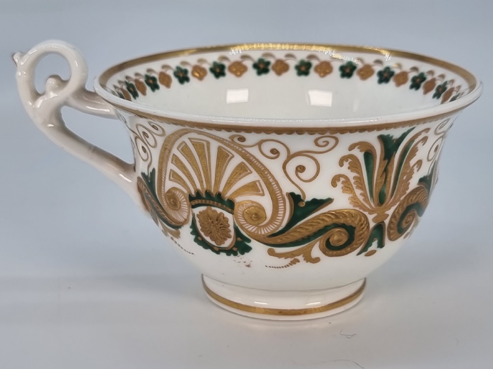 An early 19th-century Spode porcelain cabinet trio consisting of a teacup, coffee cup, and saucer adorned with intricate gold gilding and green scrollwork. View XXI