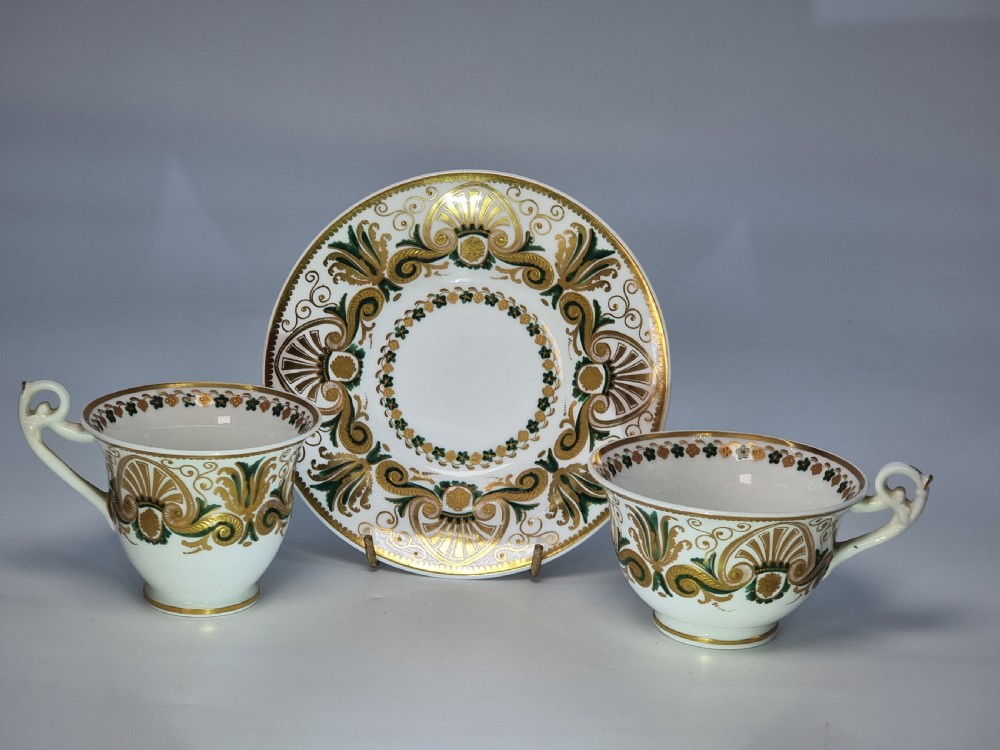 An early 19th-century Spode porcelain cabinet trio consisting of a teacup, coffee cup, and saucer adorned with intricate gold gilding and green scrollwork. View XXVI