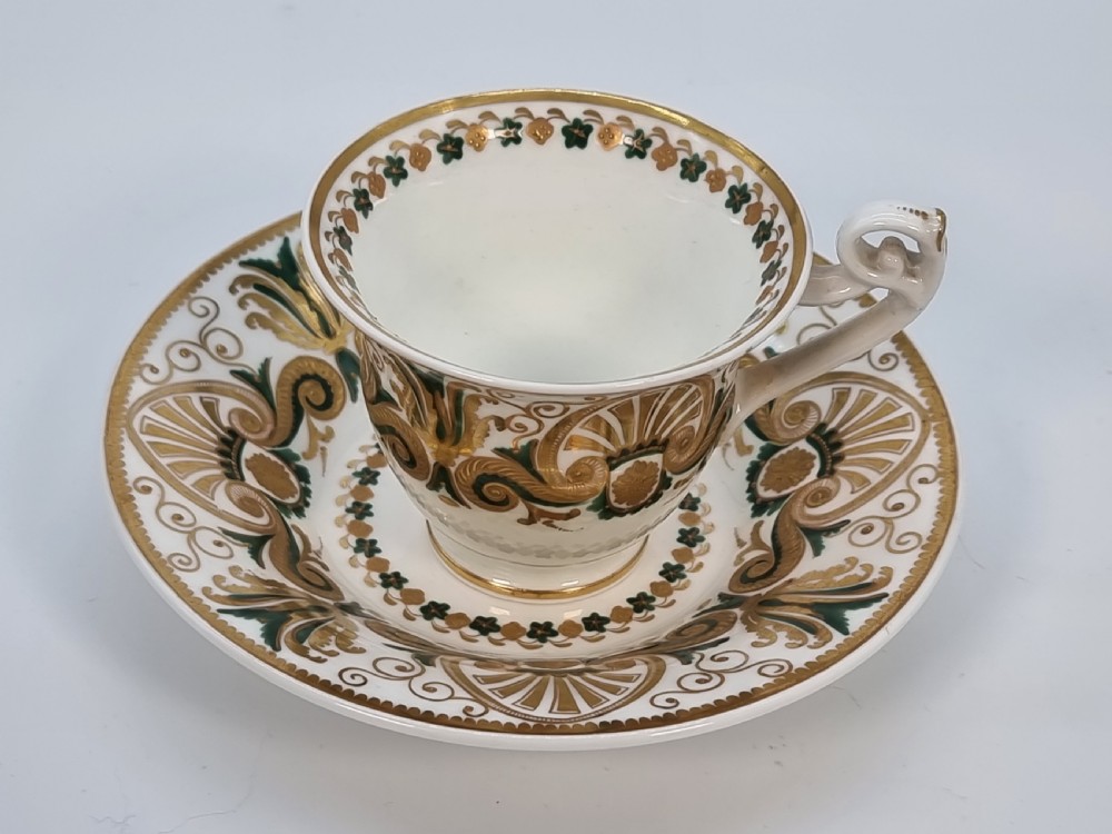 An early 19th-century Spode porcelain cabinet trio consisting of a teacup, coffee cup, and saucer adorned with intricate gold gilding and green scrollwork. View XXVIII
