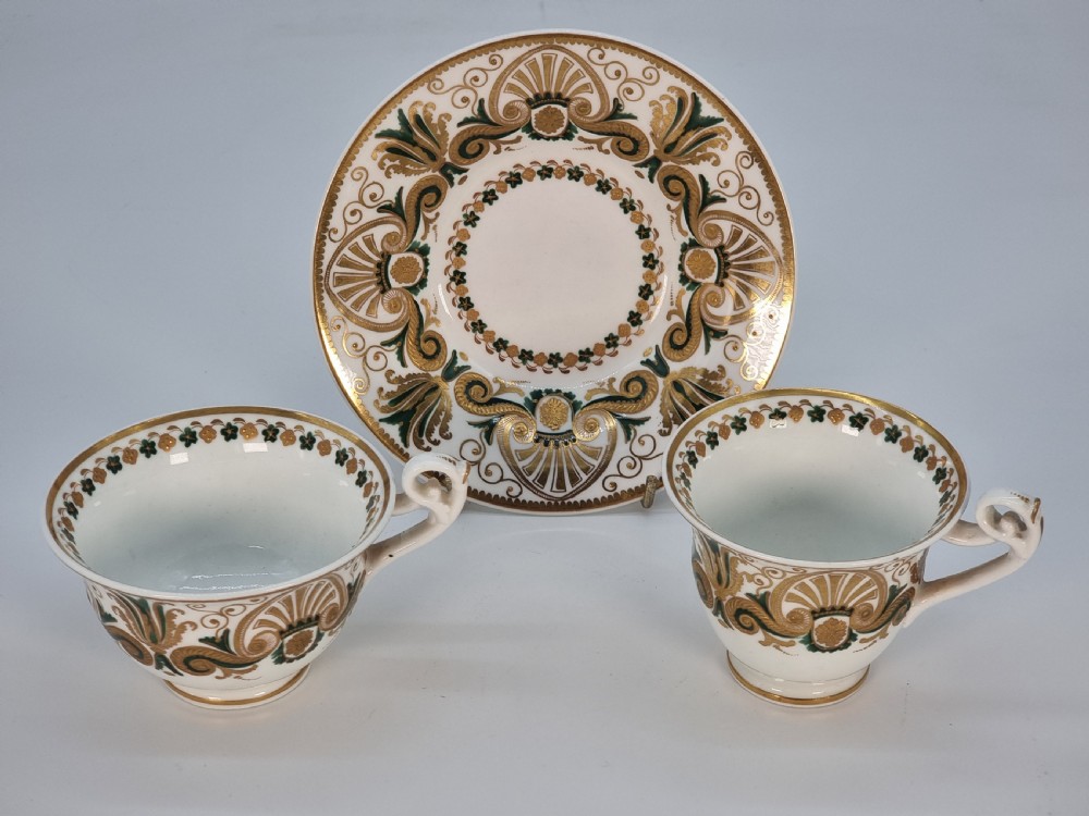 An early 19th-century Spode porcelain cabinet trio consisting of a teacup, coffee cup, and saucer adorned with intricate gold gilding and green scrollwork. View XXIX