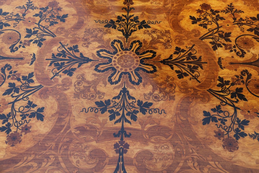 A rectangular mid-19th century satinwood centre table featuring detailed floral marquetry inlay across the tabletop, supported by carved barley twist legs and a central stretcher. View XXVI