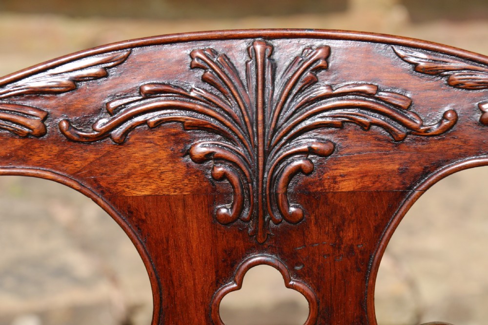A pair of 18th-century George III Chippendale period mahogany armchairs featuring pierced carved back splats and deep red buttoned leather seats with brass stud trim. View XIV