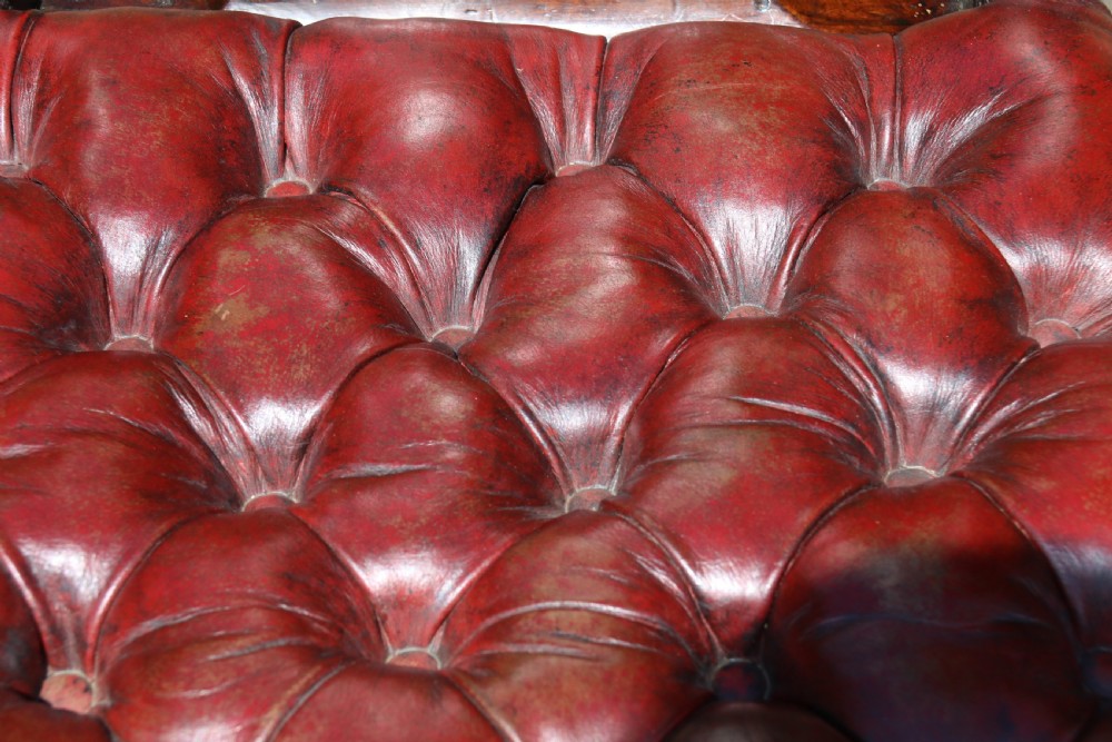 A pair of 18th-century George III Chippendale period mahogany armchairs featuring pierced carved back splats and deep red buttoned leather seats with brass stud trim. View XVI