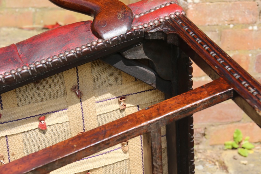 A pair of 18th-century George III Chippendale period mahogany armchairs featuring pierced carved back splats and deep red buttoned leather seats with brass stud trim. View XXII