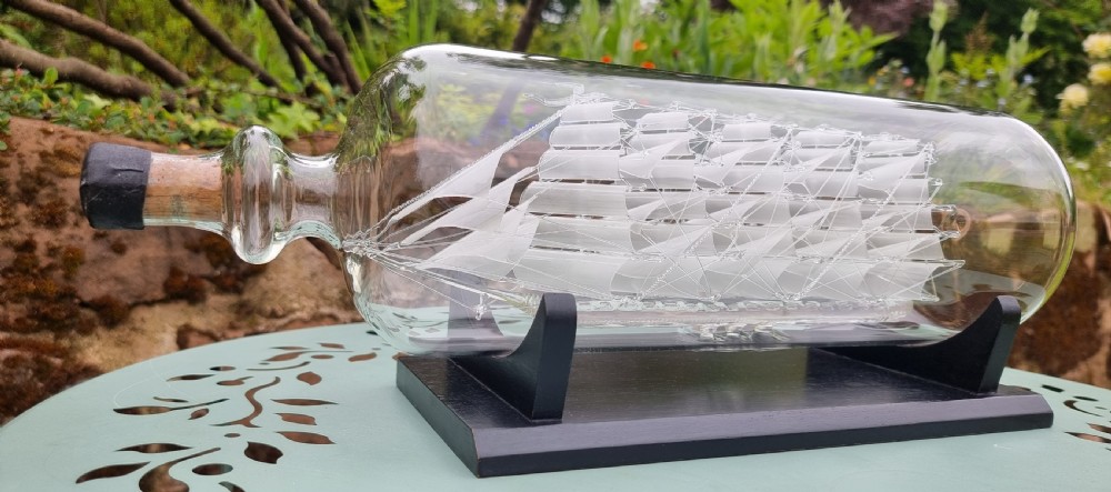An exceptionally large hand blown glass model ship in a bottle.