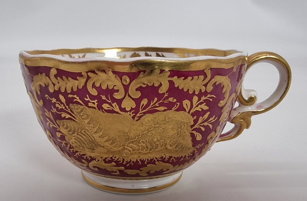 An early nineteenth-century Spode cabinet cup and matching saucer featuring a deep magenta ground embellished with heavy gold leaf scrollwork. View XI