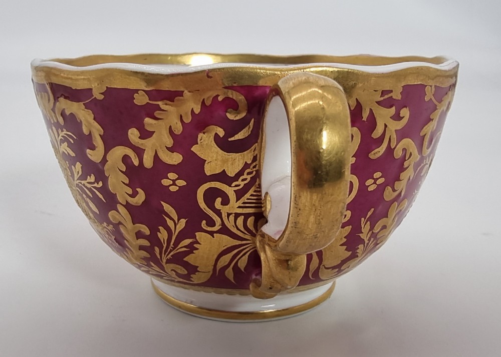 An early nineteenth-century Spode cabinet cup and matching saucer featuring a deep magenta ground embellished with heavy gold leaf scrollwork. View XV