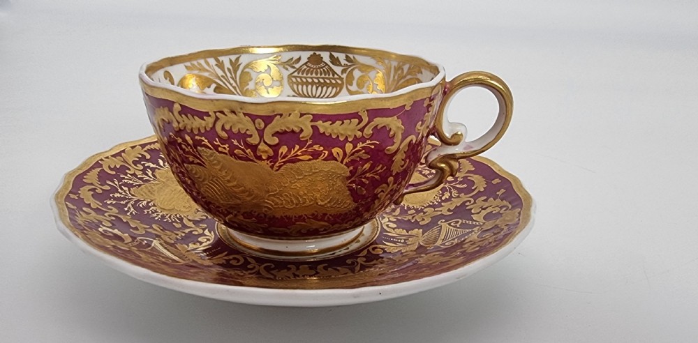 An early nineteenth-century Spode cabinet cup and matching saucer featuring a deep magenta ground embellished with heavy gold leaf scrollwork. View XIX