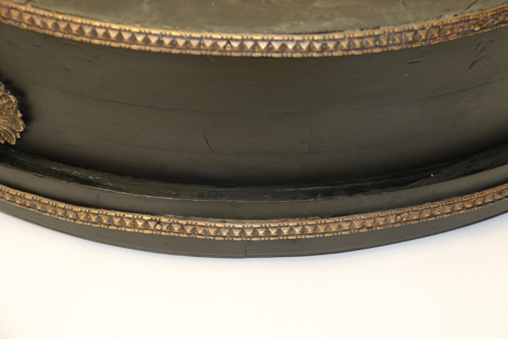 An antique French roulette wheel with ebonised wood casing and brass claw feet, set in front of an original dark green felt layout cloth printed with gold French gaming text. View VI