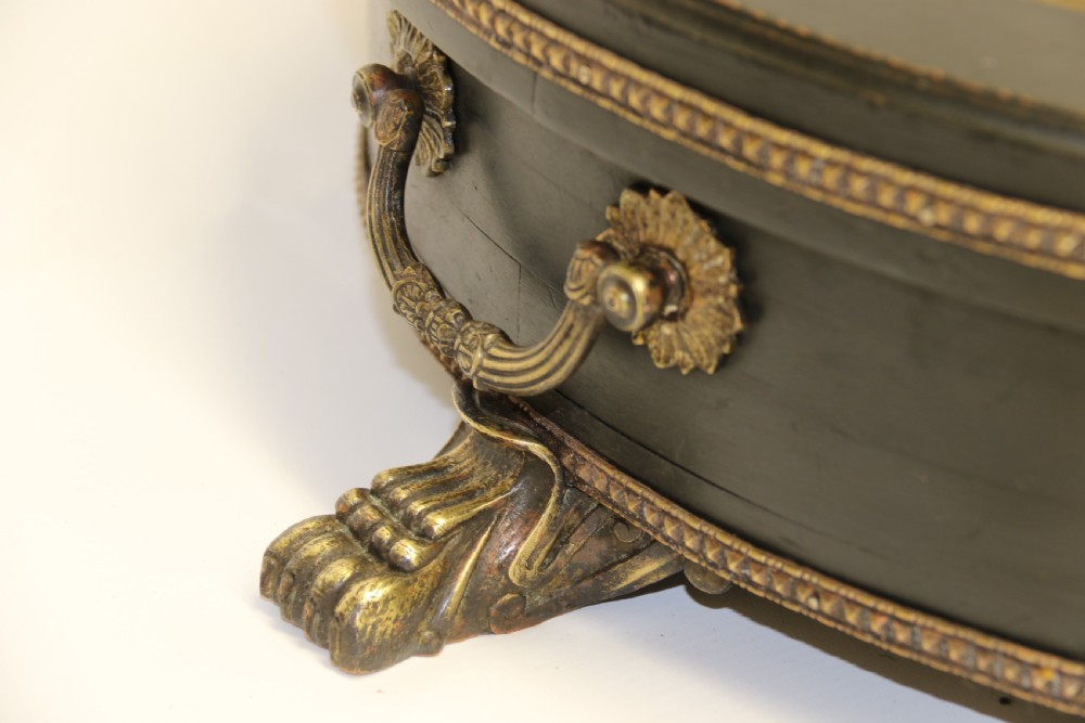 An antique French roulette wheel with ebonised wood casing and brass claw feet, set in front of an original dark green felt layout cloth printed with gold French gaming text. View XVI
