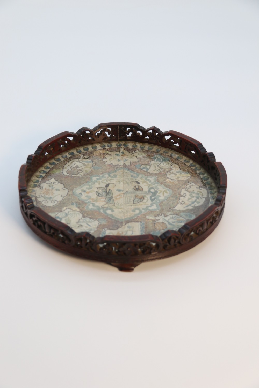 A circular carved dark hardwood tray containing an inset 19th-century Chinese silk embroidery with figural and botanical motifs. View VIII