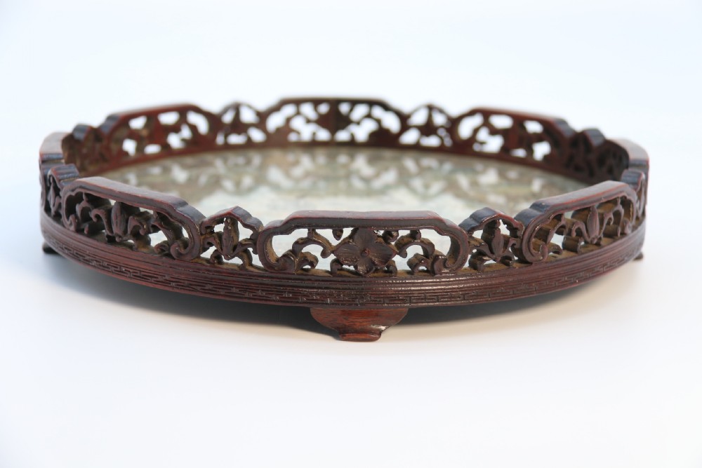 A circular carved dark hardwood tray containing an inset 19th-century Chinese silk embroidery with figural and botanical motifs. View IX