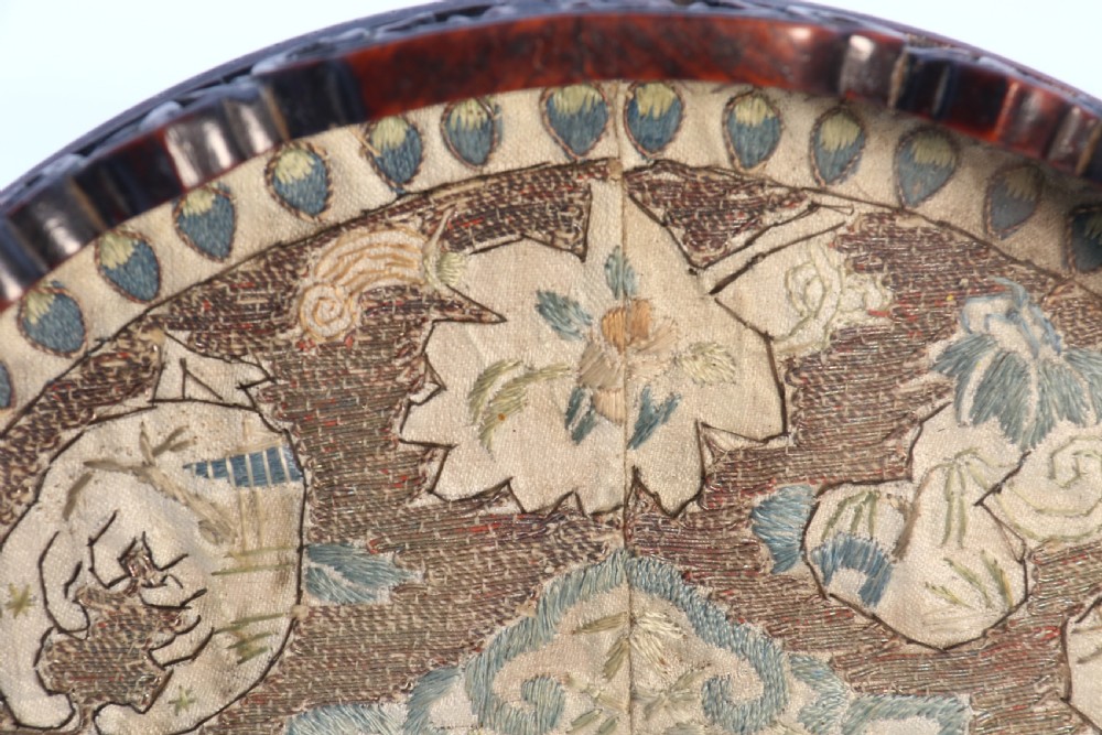 A circular carved dark hardwood tray containing an inset 19th-century Chinese silk embroidery with figural and botanical motifs. View XII
